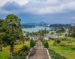 Phong cảnh Đà Lạt với hồ nước, đồi cỏ và bầu trời trong xanh trong ngày thời tiết đẹp, phù hợp cho bài viết hôm nay nên đi đâu ở Việt Nam
